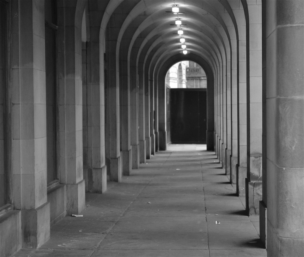 A stone arcade corridor in black and white